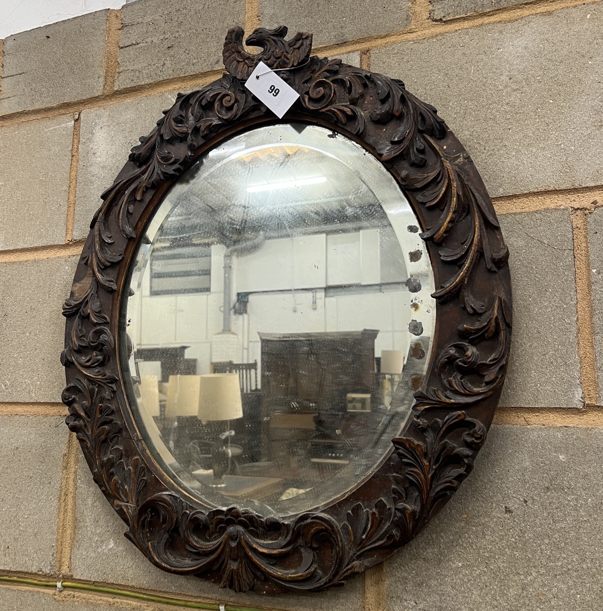 An 18th century style carved wood oval wall mirror, width 57cm, height 67cm